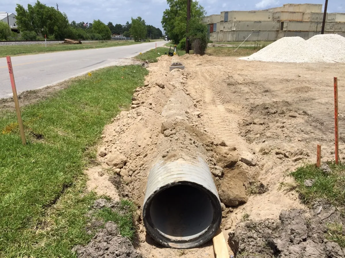 Concrete culvert pipe set in a roadside ditch before backfill on a driveway installation