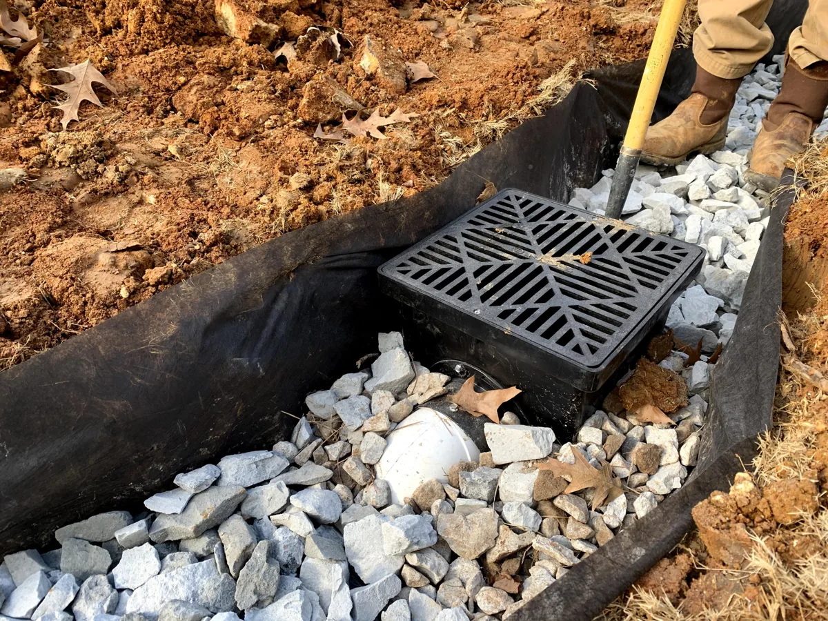 Catch basin set in washed gravel on a yard drainage installation