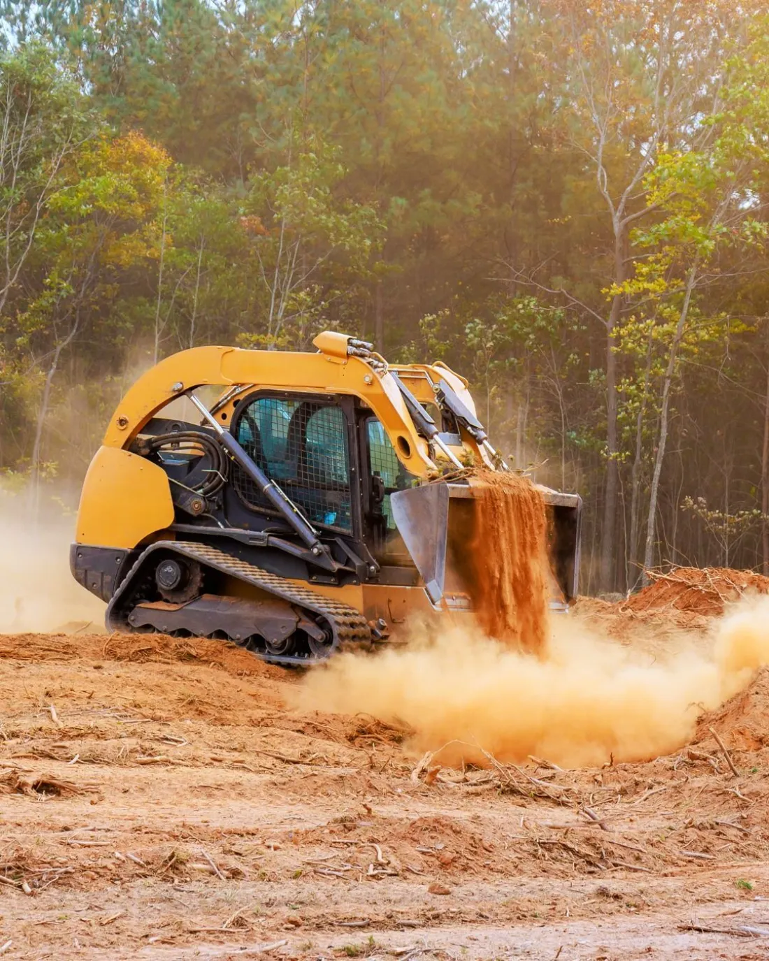 Forestry mulcher grinding dense brush into mulch on a wooded lot near Covington, LA
