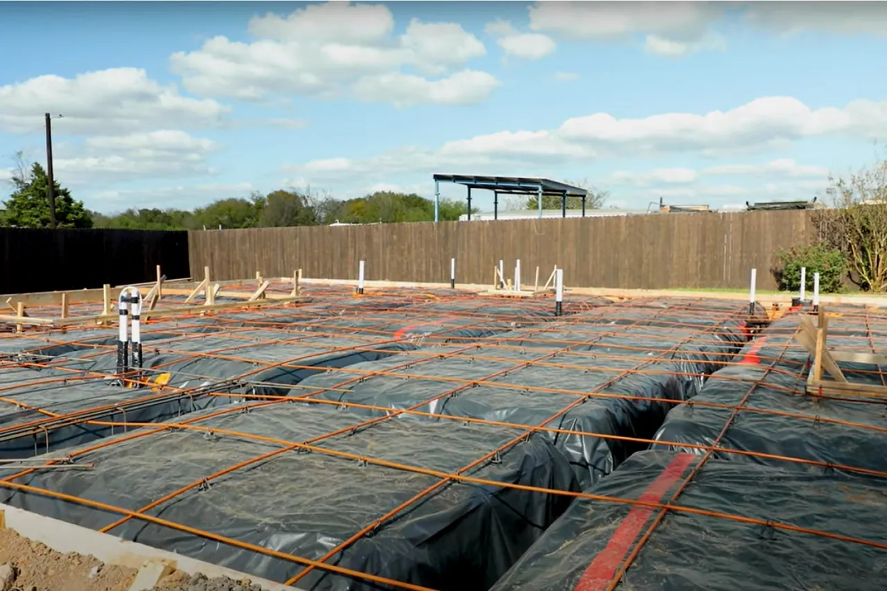 Compacted dirt house pad raised above the surrounding ground on a cleared residential lot